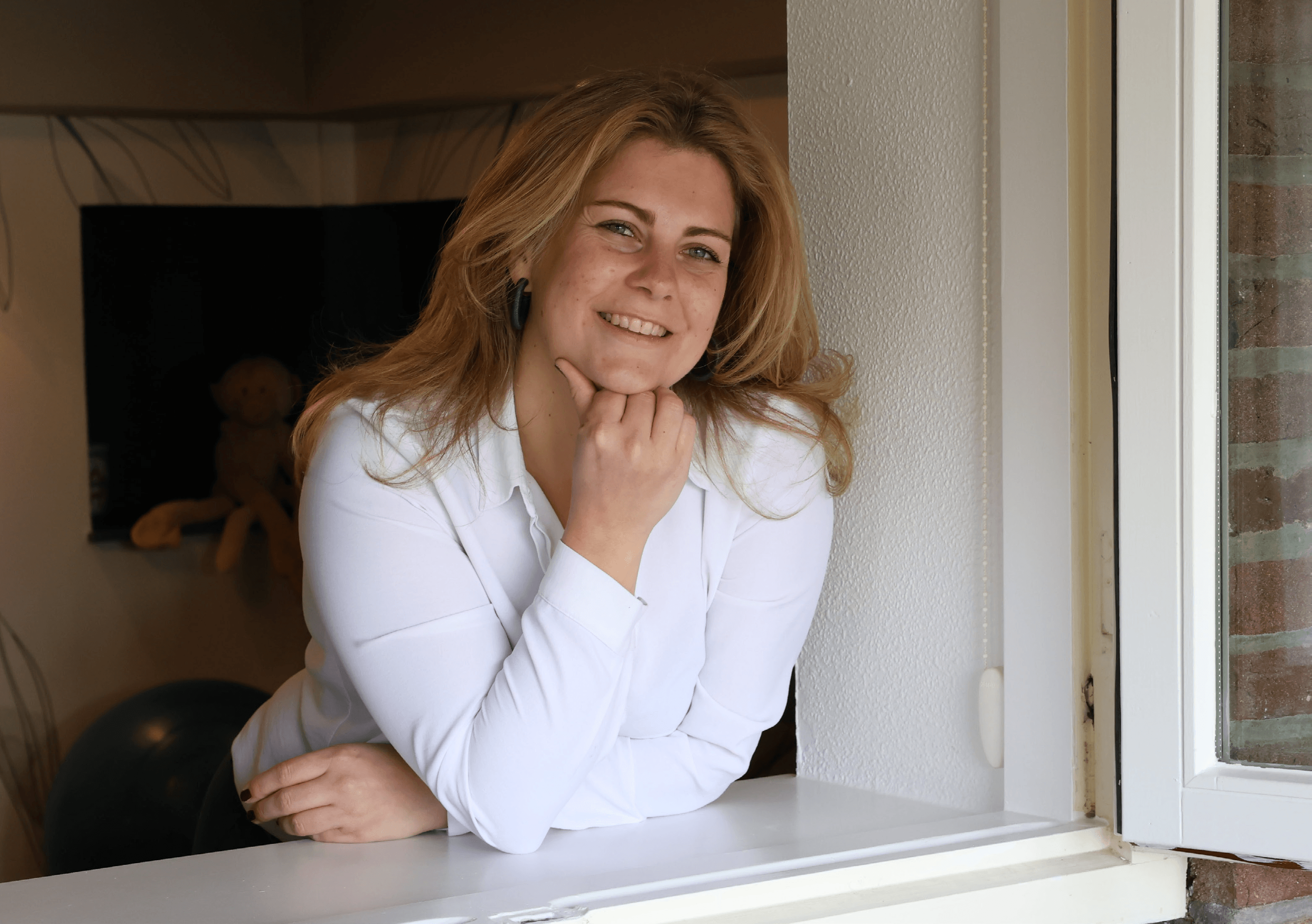 Yvonne bij het raam, glimlachend